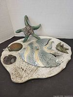 Front view of marine motif ceramic plaque showing all attached figures