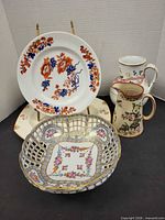 Group shot of footed bowl, two pitchers and two plates