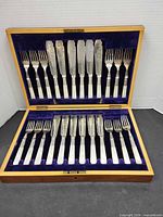 Entire set in open wood case showing 24 pieces