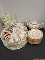 Cups stored in padded carrier, teapot and stack of saucers visible