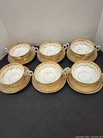 Six soup bowl and saucer sets arranged together