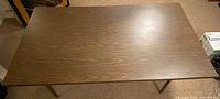 Top view of rectangular brown veneer folding table