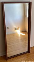 Mirror standing vertically showing full frame and glass