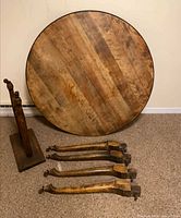 Disassembled table showing round top, four legs, base components