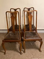 Front view of four oak Queen Anne dining chairs highlighting cabriole legs and vinyl seats
