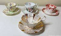 All four teacup and saucer sets displayed