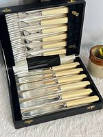 Full set arranged in original case showing six knives and six forks