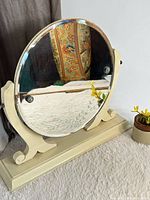 Front view showing round etched mirror on cream stand