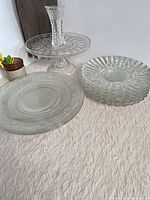 Group shot showing cake stand, bud vase, platter and stack of dessert plates