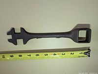 Full view of buggy wrench next to tape measure showing 9 inch length