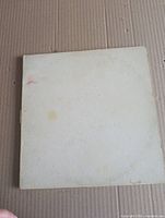 Front of worn, stained white gatefold jacket with embossed title