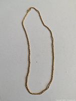Full view of gold-tone rope chain necklace laid flat