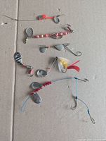 All seventeen assorted inline spinner lures laid flat showing blades, beads and hooks