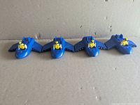 Four blue Wolverine jet toys aligned side by side