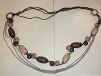 Full view of entire long necklace showing beads, chains, and hoops