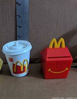Drink cup and Happy Meal box toys side by side