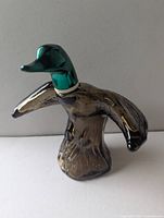 Front view of brown glass mallard in flight bottle with green head stopper