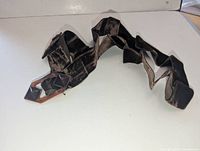 Full view of faux tortoiseshell buckle attached to dark brown velvet ribbon sash