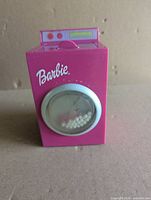 Front view showing Barbie logo, clear round door, internal beads
