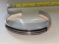 Front view showing black enamel ribbing and measuring tape for scale