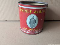Front view of red Prince Albert Crimp Cut 14-oz tobacco tin showing graphics and missing lid