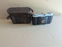 Camera closed beside leather carry case
