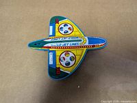 Top view of tin friction airplane showing graphics and missing tail