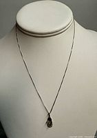 Full view of necklace on display bust showing chain length and pendant