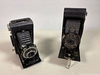 Both folding Kodak cameras side by side, bellows extended