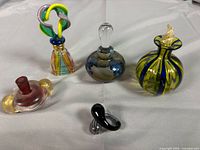 Group view of all five art glass perfume bottles and stopper
