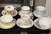 Group shot of six teacup and saucer sets on shelf