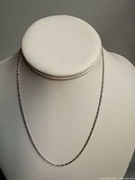 Full view of the white gold chain on display bust