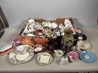 overview of box with assorted china pieces and vase