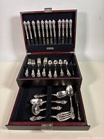 Full flatware set displayed in two-tier chest