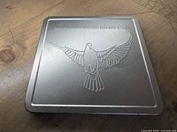 Top of embossed metal tin with dove design