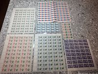 Overview of all seven Canadian stamp sheets on countertop