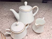 Teapot, sugar bowl, creamer showing pattern and trim