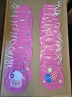 All 36 pink drawstring bags in two stacks showing both designs