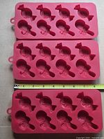 three red silicone candy molds measured at about 9 inches