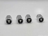 Front view of four chrome Tesla logo valve stem caps