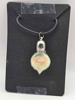 Front view of glass vial pendant on display card