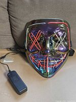 Front of iridescent mask with EL wire and battery pack