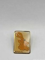 Front view showing Klakki bunny graphic and gold-tone finish