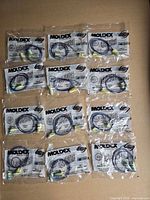 Twelve individually sealed Moldex SparkPlugs earplug packs displayed together