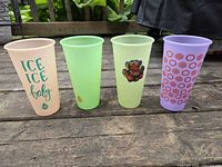 Front view of four TAL plastic cups showing colors and graphics