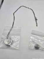 Necklace with heart locket in bag alongside bead and pin tool