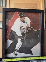 Front view of framed Team Canada hockey poster with measuring tape showing size