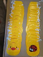 Two columns of yellow drawstring bags displaying both chick and ladybug designs