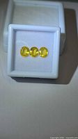 Front view of three oval yellow sapphires in display box