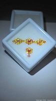 Loose round sapphires displayed in white plastic gem box, showing colour variety
